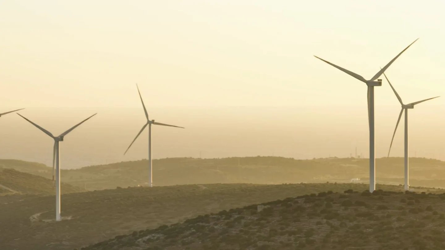 Wind turbines on hills at sunset